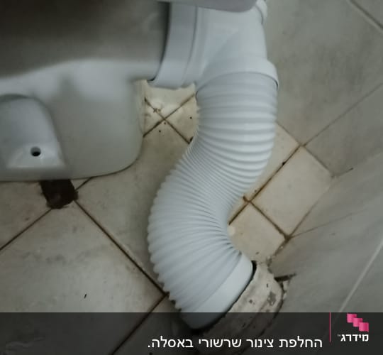 צינור גמיש מחובר לאסלה על רצפת קרמיקה